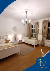 - un salon avec deux lits et un lustre dans l'établissement Augarten Apartments, à Vienne