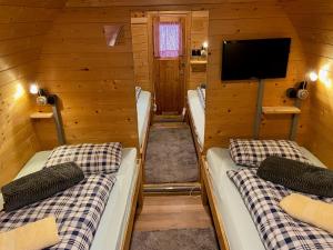 een kamer met drie bedden in een hut met een tv bij Inn-side ADVENTURE CABINS in Haiming
