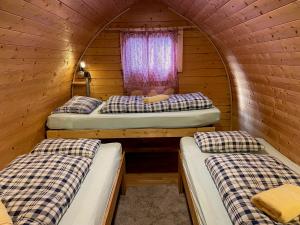 a room with two beds in a wooden cabin at Inn-side ADVENTURE CABINS in Haiming