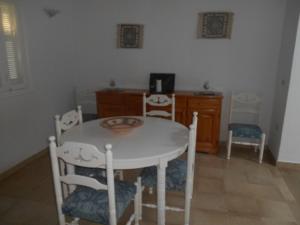 ein Esszimmer mit einem weißen Tisch und Stühlen in der Unterkunft Villa meublée à skanes Monastir in Monastir