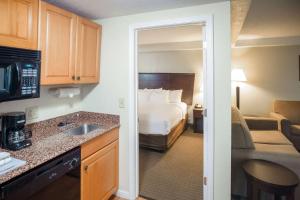 a hotel room with a bed and a kitchen at MainStay Suites Knoxville North I-75 in Knoxville