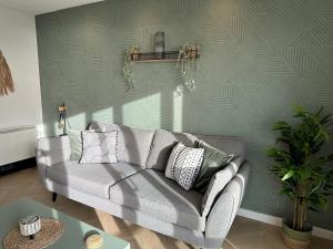 a living room with a gray couch and a table at Beach View Flat on Coastal Path in Llanelli