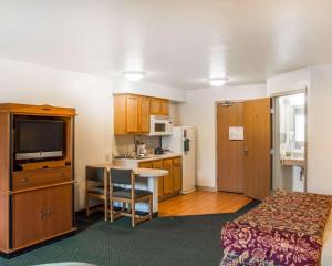 a hotel room with a bed and a kitchen with a table at Suburban Studios Dayton-WP AFB in Beavercreek