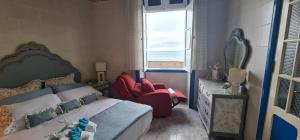a bedroom with a bed and two red chairs at Salema casa de playa en San Cristobal in Las Palmas de Gran Canaria