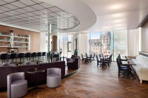 モントリオールにあるHyatt Centric Montrealのテーブルと椅子、大きな窓のあるレストラン