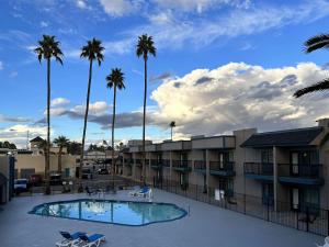 a resort with a pool and palm trees in the background at Mesa AZ Near Downtown & Sloan Park in Mesa