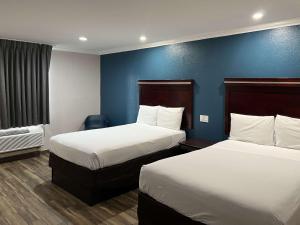 a hotel room with two beds and a blue wall at Mesa AZ Near Downtown & Sloan Park in Mesa