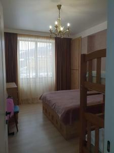 a bedroom with a bed and a chandelier at Didveli Residence Studio Apartment in Bakuriani