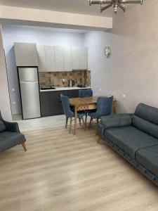 a living room with a couch and a table at Didveli Residence Studio Apartment in Bakuriani