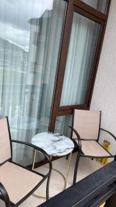 two chairs and a table on a balcony at Didveli Residence Studio Apartment in Bakuriani