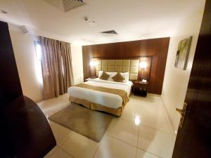 - une chambre avec un grand lit dans une chambre d'hôtel dans l'établissement Al Jury Residence Hotel Suites, à Khobar