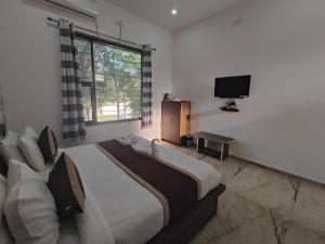a bedroom with a large bed and a television at Hill View Resort by Rudrakshi in Udaipur