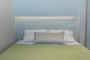 1 cama con almohadas blancas y manta verde en Nikkis Flat - Kolonaki Square en Athens