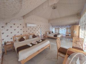 1 dormitorio con 2 camas, mesa y sillas en Hill View Resort by Rudrakshi, en Udaipur
