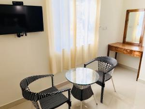 a dining room with two chairs and a glass table at Mamta courtyard anjuna in Anjuna