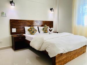 a bedroom with a large bed with a wooden headboard at Mamta courtyard anjuna in Anjuna