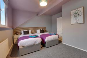 two beds in a small room with purple walls at Stylish base on Abbeydale Road in Sheffield +7 photos