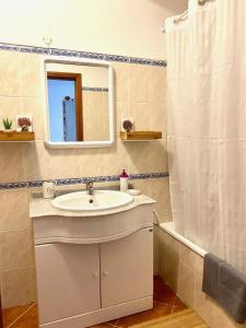 ein Bad mit einem Waschbecken, einem Spiegel und einer Dusche in der Unterkunft Sweet Home of Cabanas in Conceição