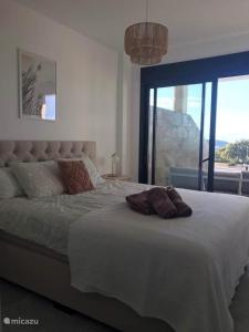 ein Schlafzimmer mit einem großen Bett und einem großen Fenster in der Unterkunft Casa Buena Vida in Finestrat