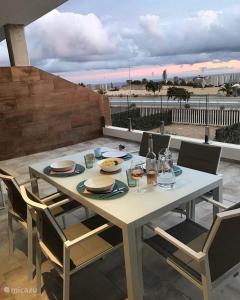 einen weißen Tisch mit Tellern und Gläsern auf einer Terrasse in der Unterkunft Casa Buena Vida in Finestrat