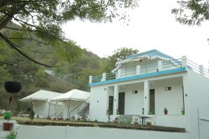 a white building with a blue roof at Hill View Resort by Rudrakshi in Udaipur