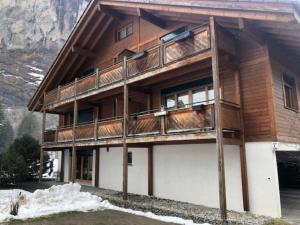 ein großes Holzgebäude mit Schnee davor in der Unterkunft Komfortabel, Perfekte Lage, neue Wohnung, gratis P in Lauterbrunnen