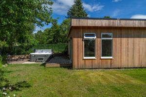 a tiny house with a deck and a stove at Allt Mor Rentals - Chalet with hot tub, And Studio Apartment no hot tub in Roybridge