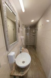 y baño con lavabo y ducha. en Papuli rooms 4U, en Senta