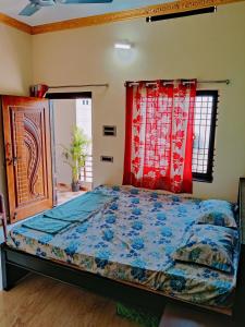 1 dormitorio con 1 cama con edredón azul en Balaji Homestay en Hampi