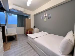 1 dormitorio con 1 cama y TV en FengChia FUN House, en Taichung