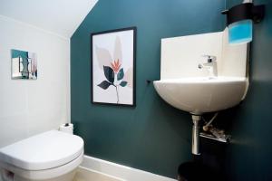 a bathroom with a white toilet and a sink at Luxury new built split-level flat with rooftop gardens access in Manchester