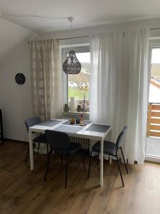 een eettafel en stoelen in een kamer met een raam bij Ferienwohnung Ela in Bad Kissingen