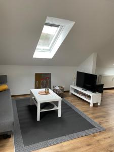 een woonkamer met een witte tafel en een dakraam bij Ferienwohnung Ela in Bad Kissingen