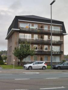 un edificio con dos coches estacionados frente a él en Q Geraardsbergen, en Geraardsbergen