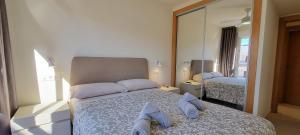 A bed or beds in a room at Homes of Spain, Apartamentos Paraíso, Ed Tahiti, Atico A a pie de Playa, piscina privada en solárium, WI-FI