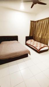 a bedroom with two beds and a ceiling fan at The Quintet Condominium 3-1 in Tanah Rata