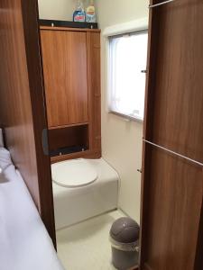 a small bathroom with a toilet and a window at Gezellige luxe caravan met zwembad in zuid- Bourgogne in Anglure-sous-Dun +15 photos
