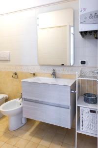 ein Badezimmer mit einem Waschbecken, einem WC und einem Spiegel in der Unterkunft N213 - Numana, nuovo bilocale in centro in Numana