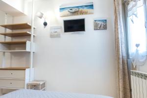 a bedroom with a bed and a tv on a wall at N213 - Numana, nuovo bilocale in centro in Numana