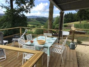una mesa y sillas en una terraza con vistas en Gezellige luxe caravan met zwembad in zuid- Bourgogne en Anglure-sous-Dun