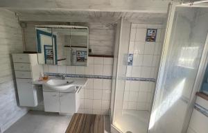 a white bathroom with a sink and a shower at Ostseehaus am Wasser in Barth