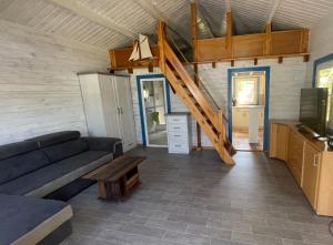 ein Wohnzimmer mit einem Sofa und einer Treppe in der Unterkunft Ostseehaus am Wasser in Barth