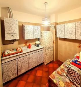 a kitchen with white cabinets and a red tile floor at B&B Margot in Albavilla