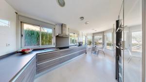 a kitchen with white walls and windows and a counter at Villa Sol in L'Ampolla
