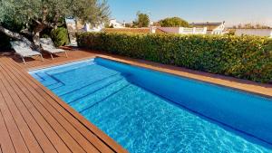 a blue swimming pool on a wooden deck at Villa Sol in L'Ampolla