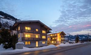 a large building with lights on in the snow at Auhof - Apartments Bad Gastein in Bad Gastein