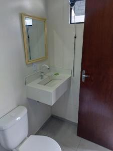 uma casa de banho com um lavatório, um WC e um espelho. em Hospedagem Quinta do Correia em Penha