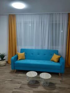 un canapé bleu dans un salon avec deux tables dans l'établissement Apartment Petra, à Žabljak