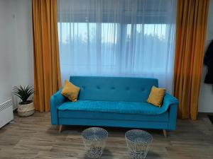 - un canapé bleu devant une grande fenêtre dans l'établissement Apartment Petra, à Žabljak 148 autres photos