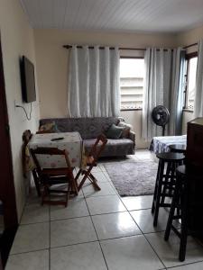 ein Wohnzimmer mit einem Sofa und einem Tisch in der Unterkunft Centro De Arraial Do Cabo in Arraial do Cabo